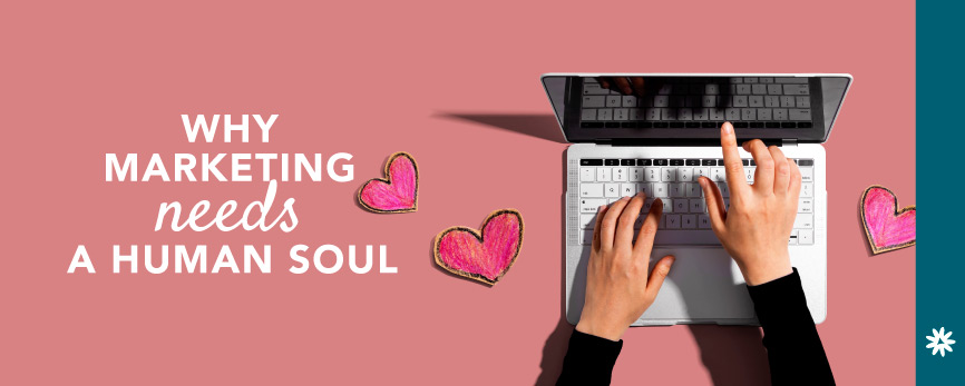 a person typing on a laptop with paper hearts scattered around in a blog post about AI, marketing, and a human soul